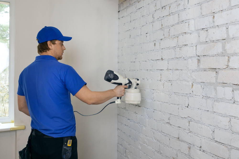 Man,Painting,Old,Brick,Wall,In,White,Color,With,Paint
