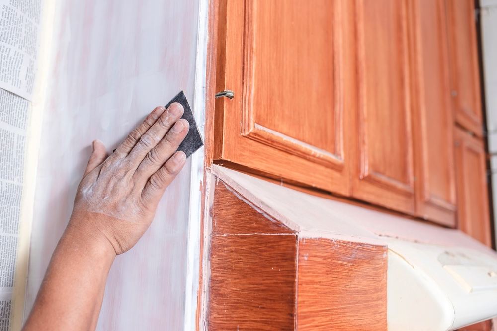A,Handyman,Using,A,Piece,Of,Sandpaper,To,Smoothen,Out